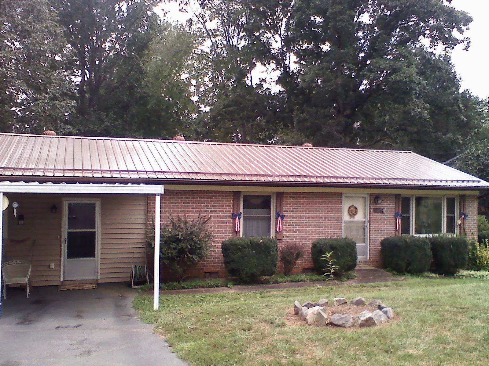 Bronze metal roof and carport on a brick ranch home — Roof Repair work by our crew in Davenport